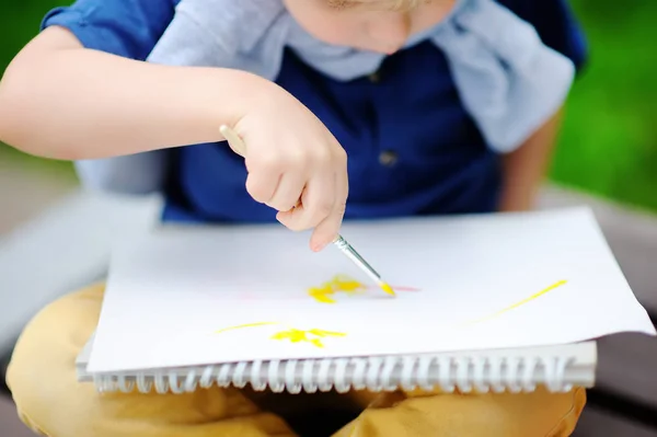 Milý chlapeček kreslení s barevnými laky v letním parku — Stock fotografie