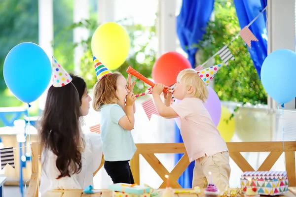 Pequeño niño y su madre celebran fiesta de cumpleaños con decoración colorida y pasteles con decoración colorida y pastel — Foto de Stock