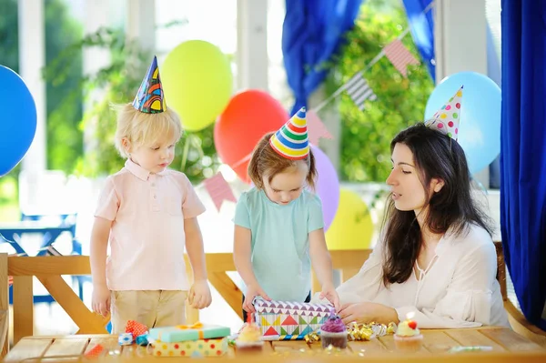 Petit enfant et leur mère fêtent leur anniversaire avec une décoration colorée et des gâteaux avec une décoration colorée et un gâteau — Photo