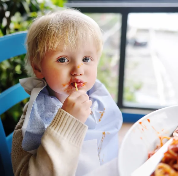 Bonito menino de criança comendo macarrão em italiano dentro de casa restaurante — Fotografia de Stock