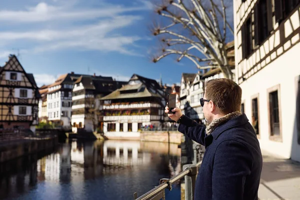 Middelbare leeftijd toeristische maken van mobiele foto van de beroemde wijk "La Petite France" in Straatsburg, Elzas, Frankrijk. — Stockfoto