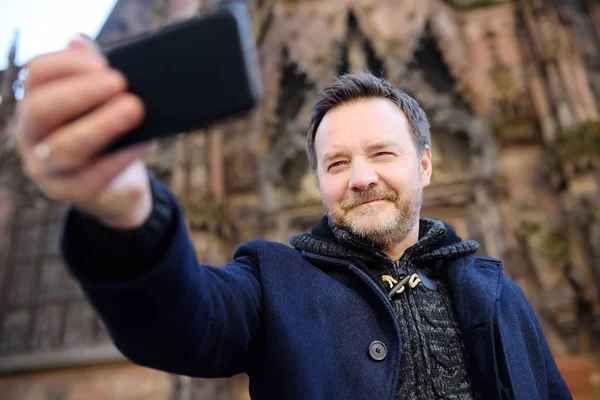 Turista de la Edad Media haciendo foto móvil selfie con famoso? athedral Notre Dame de Estrasburgo en el fondo — Foto de Stock