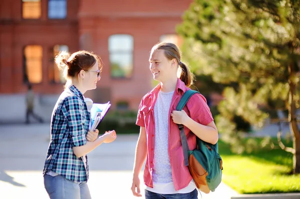 Giovani studenti felici con libri e appunti nel campus universitario — Foto Stock