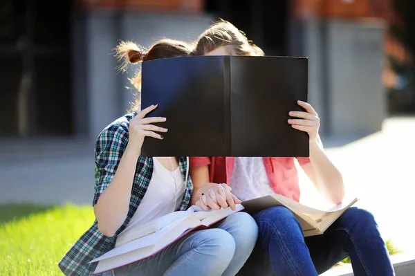 Молодые счастливые студенты целуются и держатся за руки — стоковое фото