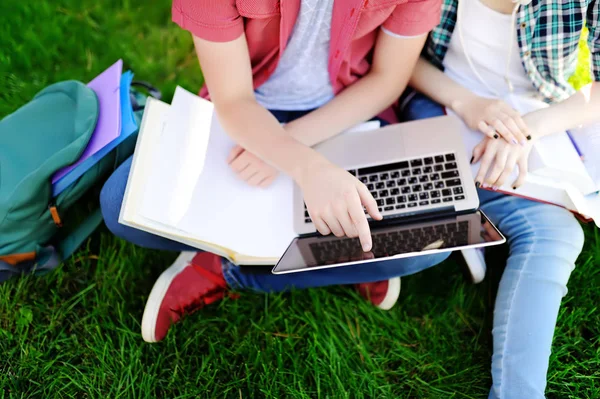 Jeunes étudiants heureux avec ordinateur portable, livres et notes à l'extérieur — Photo