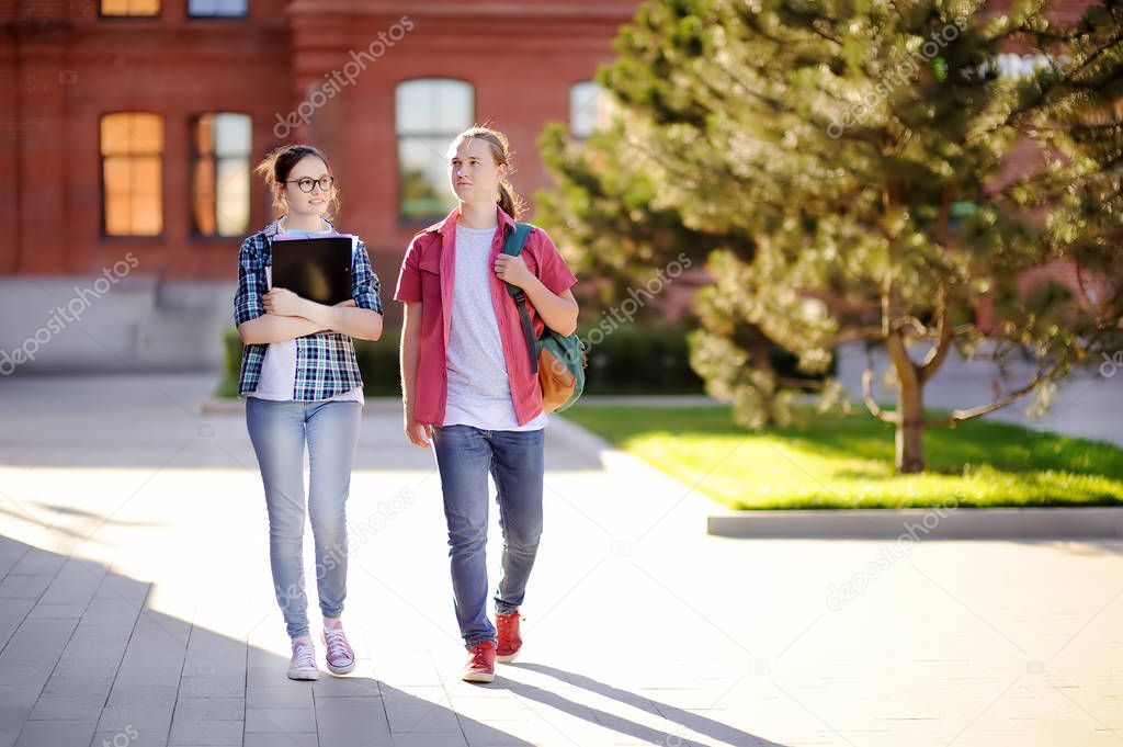 Young happy students with books and notes in University campus