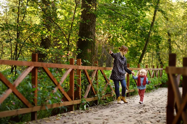 森の中を散歩中に話している若い母親を持った少年 — ストック写真