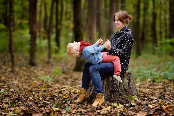 Liten pojke med sin unga mamma ha kul under promenad i skogen — Stockfoto