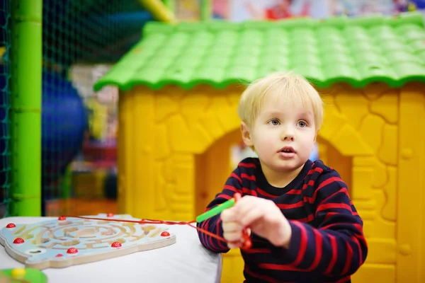 Счастливый мальчик развлекается с развивающей игрушкой в игровом центре — стоковое фото