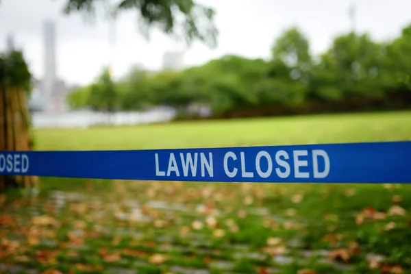 Cautions tape with writing "Lawn closed" means, that access on lawn forbidden. — Stock Photo, Image