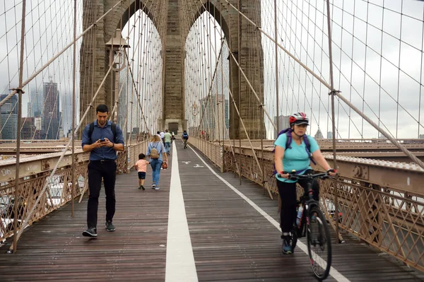 NOVA IORQUE, EUA - 12 DE JULHO DE 2019: Os pedestres caminham sobre a Ponte do Brooklyn ao pôr do sol . — Fotografia de Stock