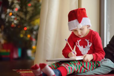 Küçük çocuk Noel Baba 'ya mektup yazıyor. Çocuk alabileceği bir hediyeyi hayal eder.