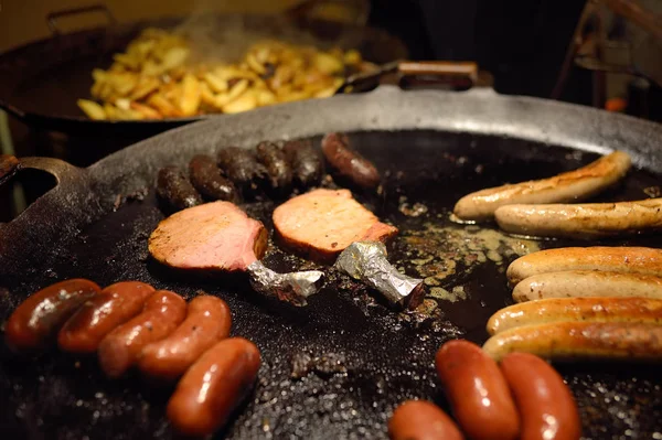 Comida quente na feira de Natal de Tallinn. Como tradicionais salsichas e kupaty está cozinhando em uma fogueira . — Fotografia de Stock
