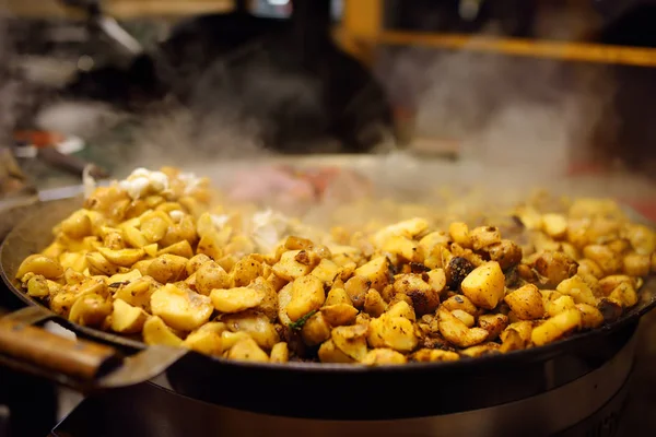 Comida quente na feira de Natal de Tallinn. Batatas fritas na grande panela da cozinha . — Fotografia de Stock