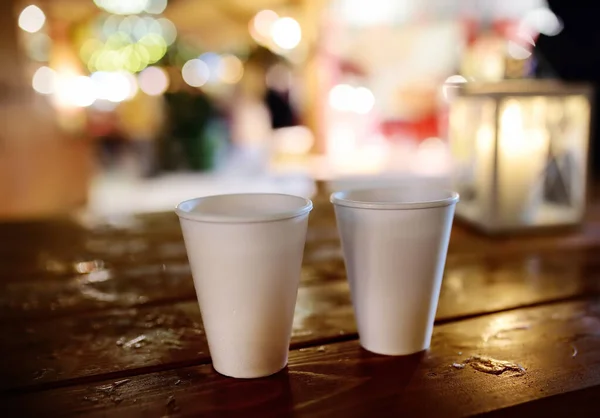 Пара одноразовых чашек на деревянном столе на Рождественской улице. Рождественские праздники на знаменитой ярмарке в Таллинне, Эстония . — стоковое фото