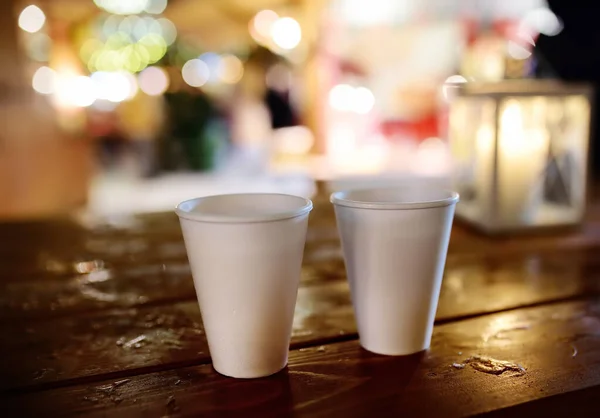 Par de copos descartáveis em uma mesa de madeira no mercado de rua de Natal. Férias de Natal na famosa feira em Tallinn, Estónia . — Fotografia de Stock