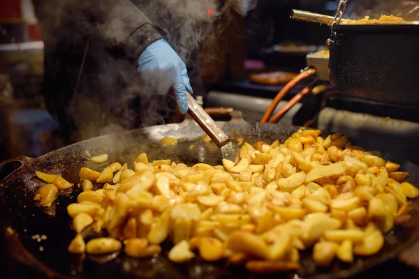 Comida quente na feira de Natal de Tallinn. Batatas fritas na grande panela da cozinha . — Fotografia de Stock