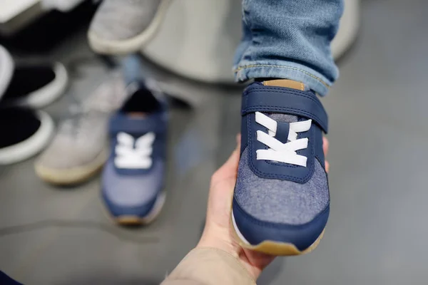 Little boy during shopping with his mother. Kid trying new fashion seasonal sneakers. — Stock Photo, Image