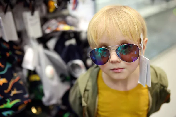 Μικρό αγόρι επιλογή των γυαλιών ηλίου στο κατάστημα. — Φωτογραφία Αρχείου