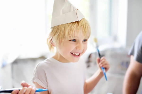 Kleine jongen heeft plezier met verf borstel tijdens reparatie van de kamer — Stockfoto