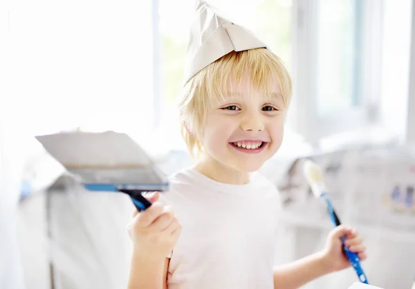 Маленький хлопчик розважається з пензлем під час ремонту кімнати — стокове фото