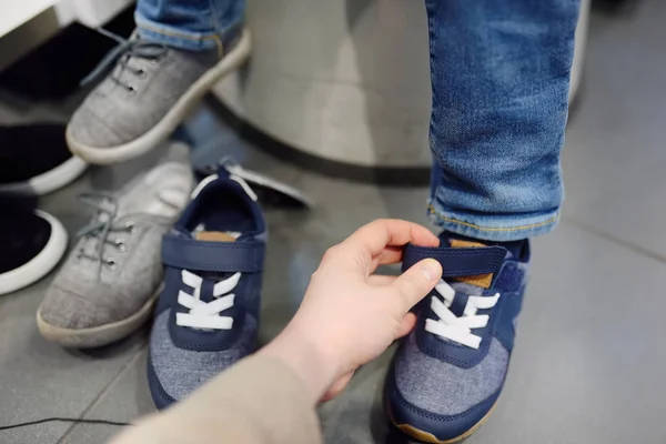 Little boy during shopping with his mother. Kid trying new fashion seasonal sneakers. — Stock Photo, Image