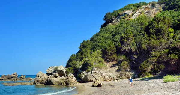 ギリシャの海岸沿いの砂漠の湾を歩いている男の子,西ペロポネソス半島 — ストック写真