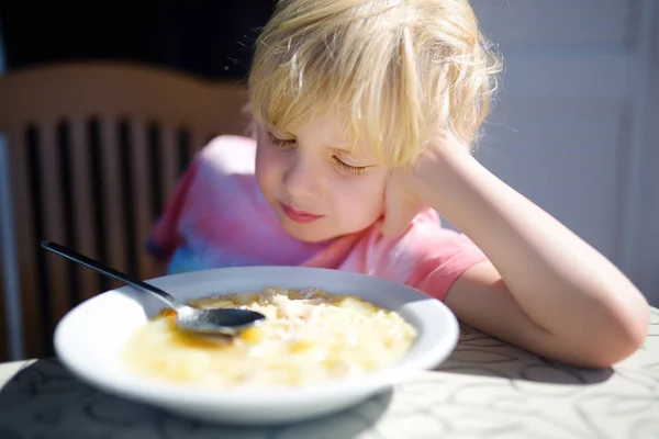 Мальчик сидит за столом и не хочет есть суп. Здоровое питание . — стоковое фото