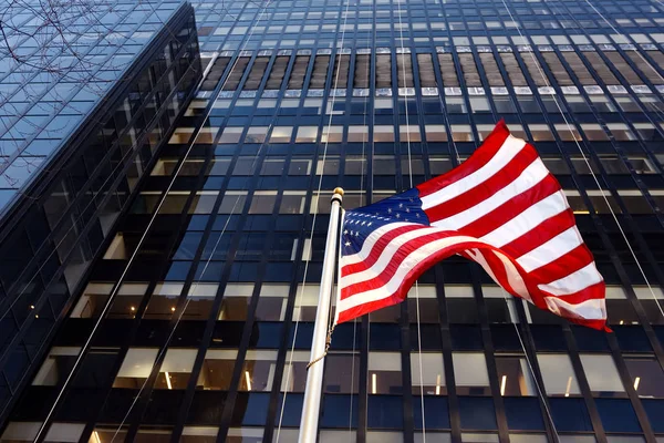 Ondeando la bandera americana en el fondo del rascacielos en Nueva York, EE.UU. . —  Fotos de Stock