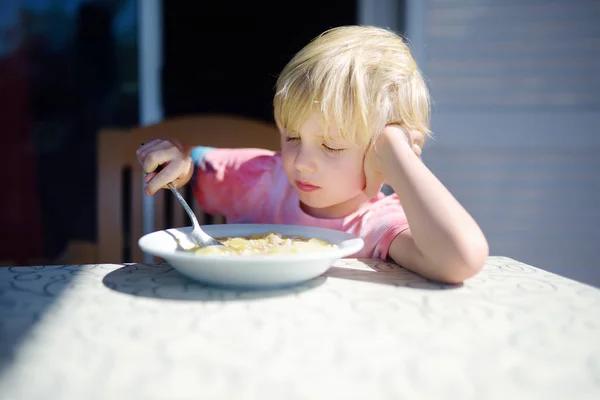 Мальчик сидит за столом и не хочет есть суп. Здоровое питание . — стоковое фото