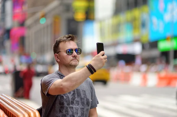 Homem turista tiro ou tirar selfie em Times Square no dia ensolarado de verão, centro de Manhattan, Nova York . — Fotografia de Stock