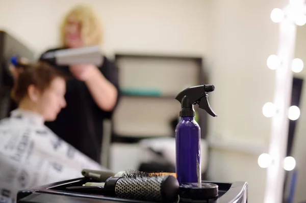 Hairdresser making hairstyle for middle age woman in beauty salon. Focus on hairdressing tools close up. — 스톡 사진