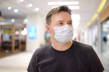 Man wearing disposable medical mask in airport or supermarket during coronavirus pneumonia outbreak. Protection and prevent measures while epidemic time. clipart