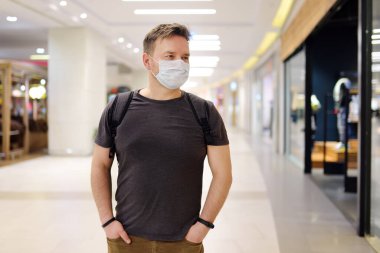 Havaalanında ya da koronavirüs salgını sırasında süpermarkette tek kullanımlık maske takan bir adam. Salgın sırasında tedbirlerin korunması ve önlenmesi.