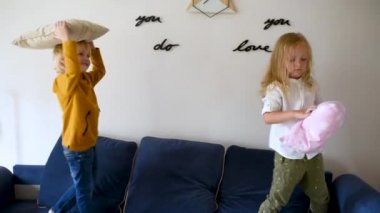 Yastık savaşı. Yaramaz anaokulu çocukları kanepeye atlayıp birbirlerine yastıklarla vuruyorlar. Erkek ve kız birlikte oynuyorlar. Kardeşler için evde aktif oyunlar.