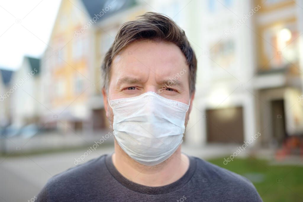 Man wearing a protective mask on urban street. Safety during COVID-19 outbreak. Pandemic of coronavirus.