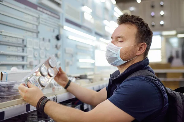 Middelbare Leeftijd Man Dragen Bescherming Gezichtsmasker Kiezen Elektrische Lampen Een — Stockfoto