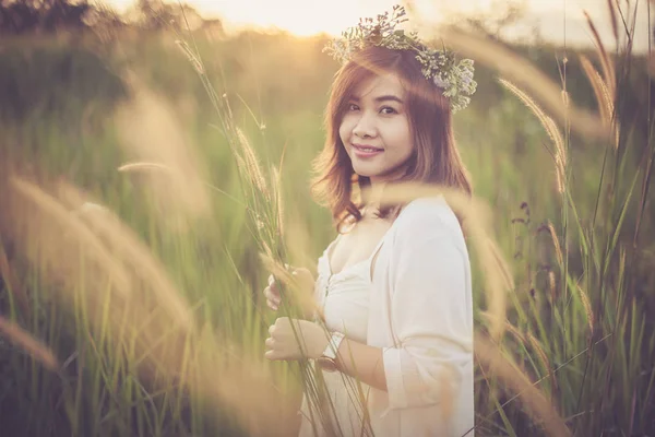 Jovem mulher asiática posando em campo dourado ao pôr do sol — Fotografia de Stock