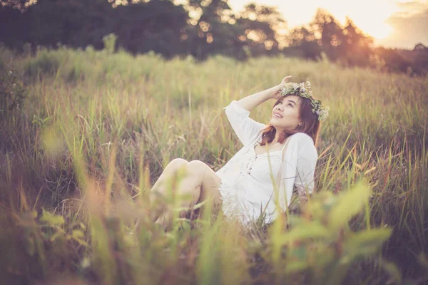 Ung asiatisk kvinna poserar i gyllene fält på sunset — Stockfoto