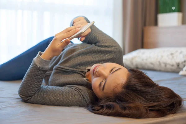 Akıllı telefon kullanan genç bir kadın.