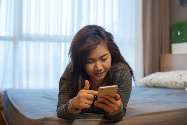 Młoda kobieta korzystająca ze smartfona — Zdjęcie stockowe