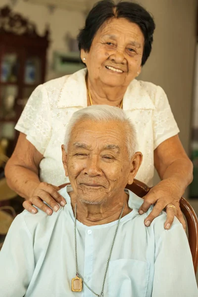 Senior woman giving a massage to her husband at home — Stock Photo, Image