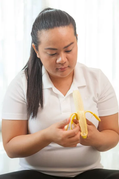 Λίπος γυναίκα της Ασίας με μπανάνα σε λευκό — Φωτογραφία Αρχείου