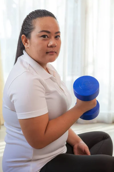 Jovem asiático mulher gorda faz fitness com haltere em casa — Fotografia de Stock