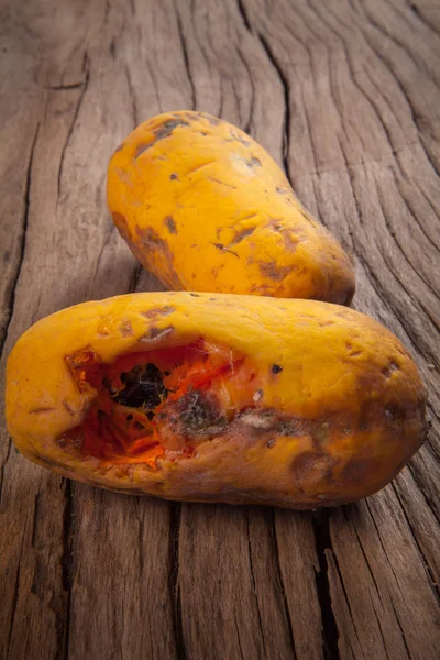 Close-up van beschimmeld papaja fruit op hout achtergrond — Stockfoto