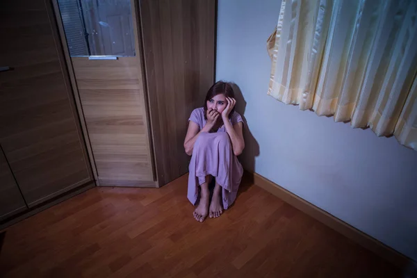 Scared abused woman sitting in the corner of the room — Stock Photo, Image