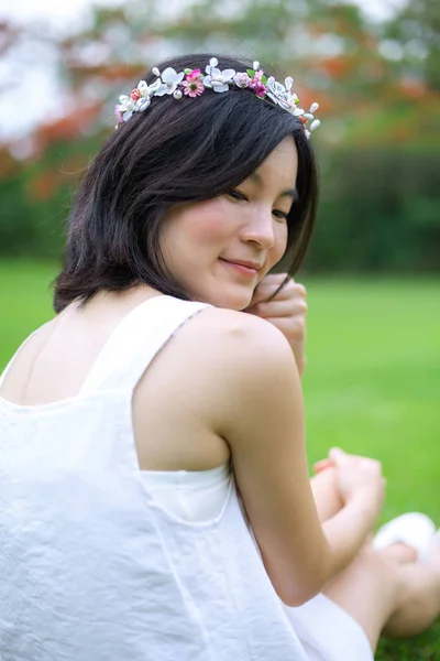 Jonge vrouw met een kroon van bloemen — Stockfoto