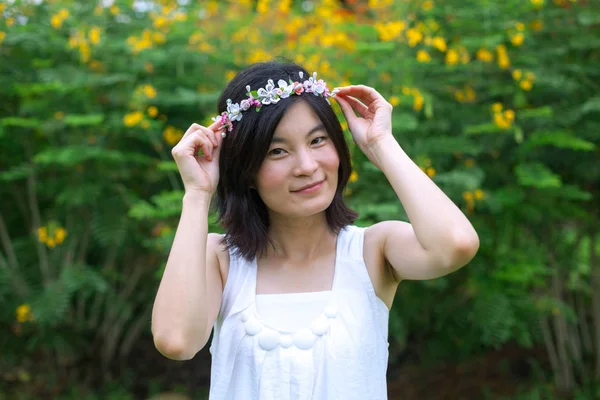 Jonge vrouw met een kroon van bloemen — Stockfoto