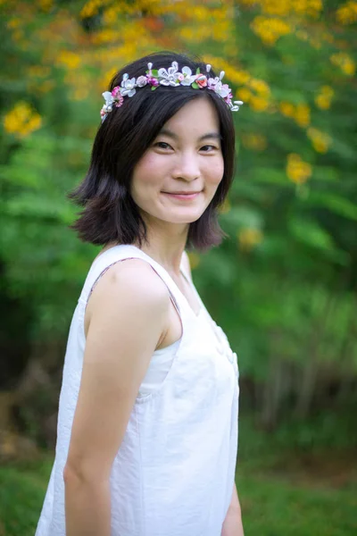 Jonge vrouw met een kroon van bloemen — Stockfoto