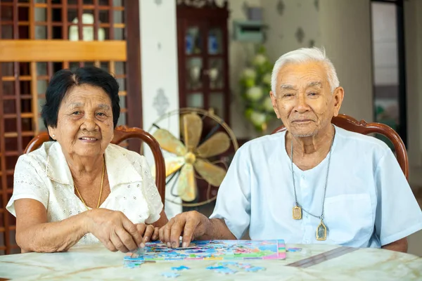 Paar senior spelen met een puzzel thuis — Stockfoto